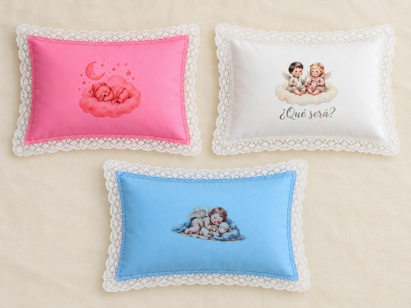 Composición de tres almohaditas con funda rosa, blanca y celeste, separadas y con encaje blanco.