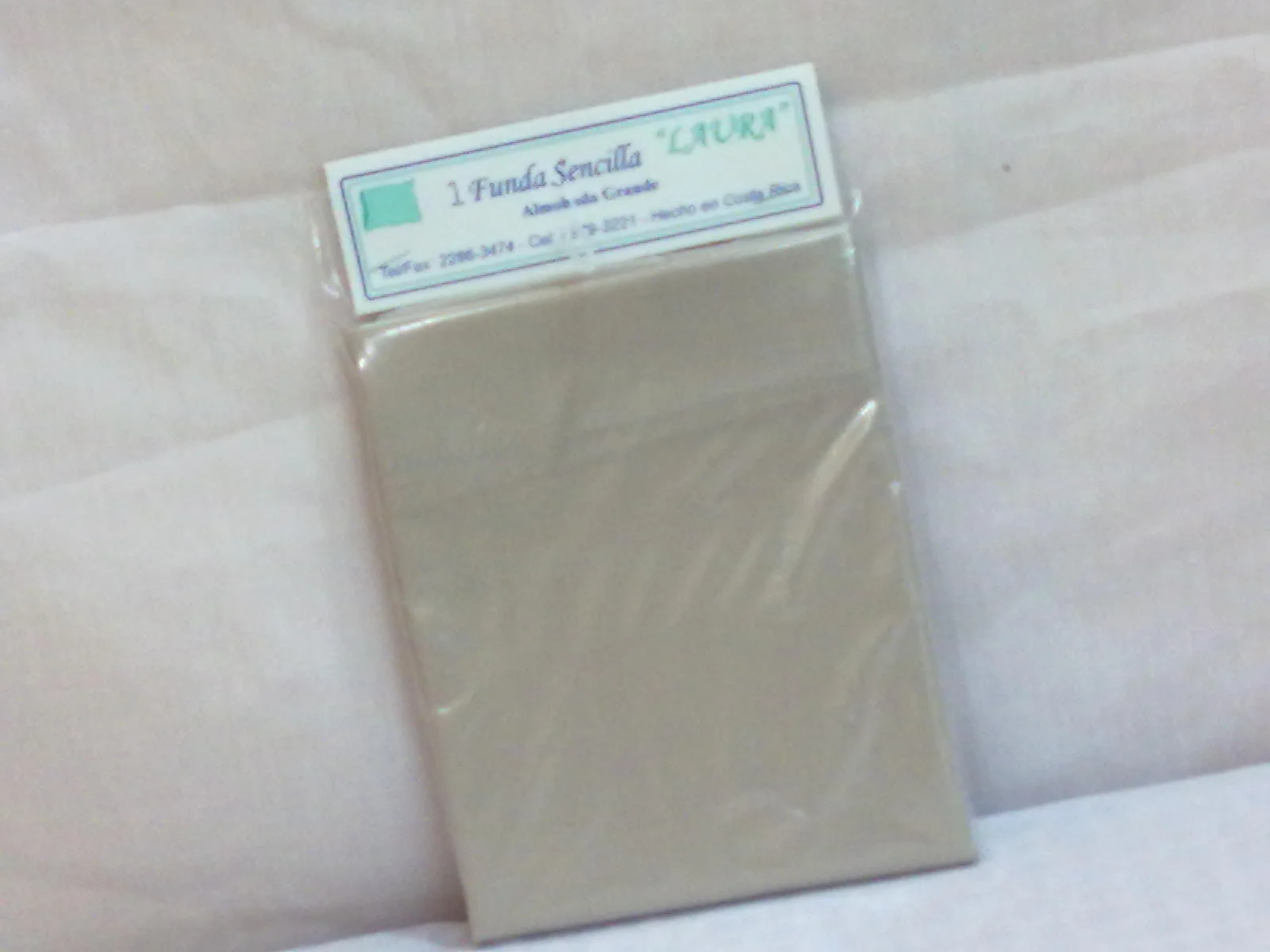 Fotografía de archivo de una funda blanca para almohada grande, en su empaque.